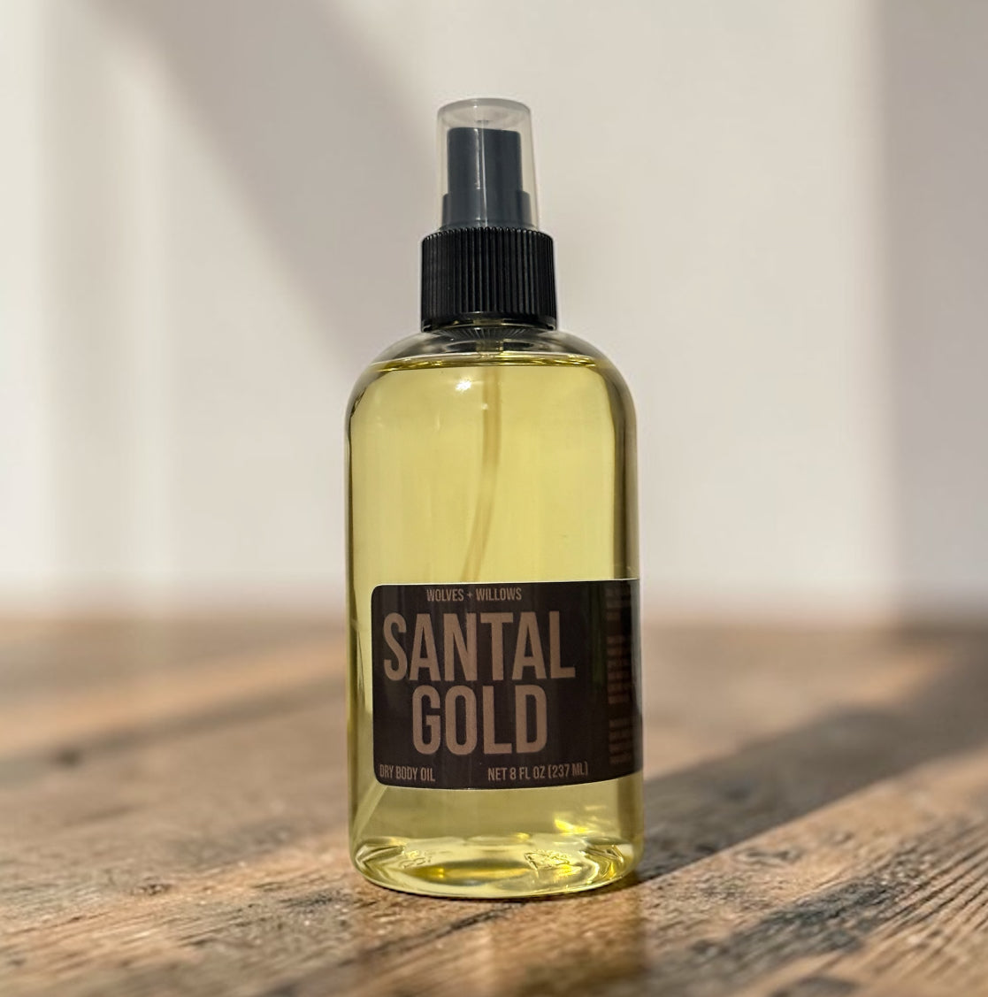 Bottle of Santal Gold on a wooden surface with a neutral background
