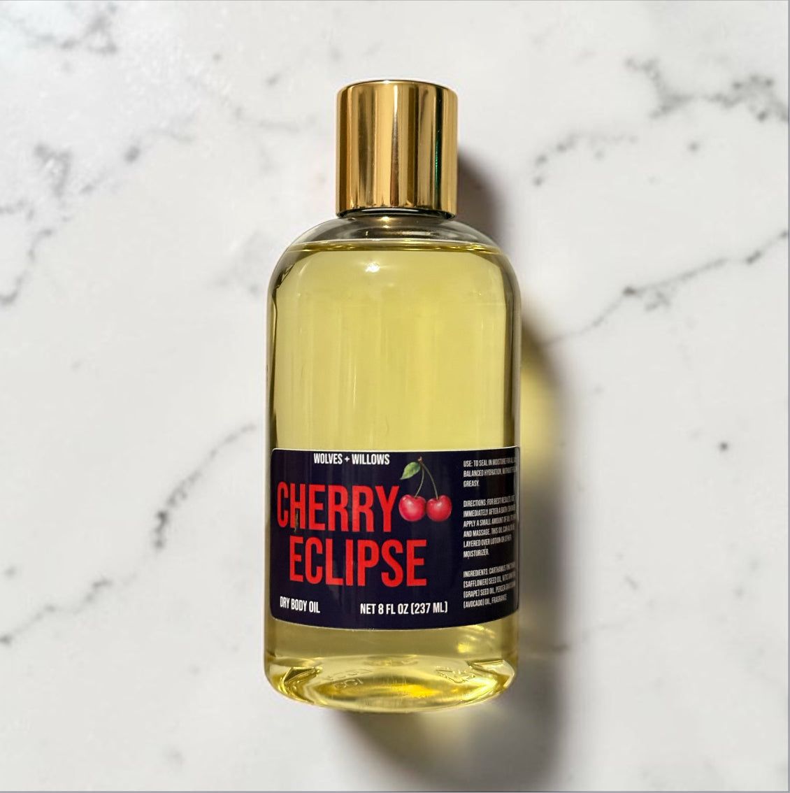 Bottle of 'Cherry Eclipse' body oil on a marble surface