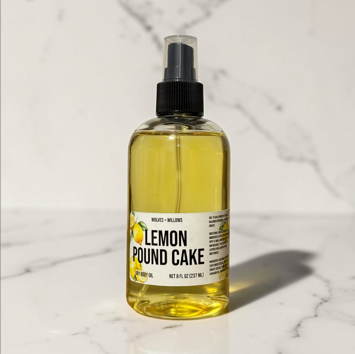 Bottle of lemon pound cake-scented body oil on a marble surface