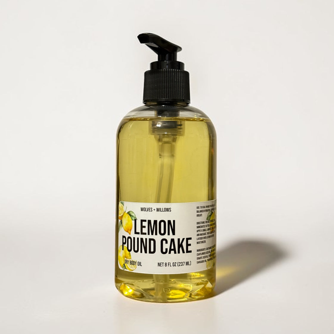Bottle of lemon pound cake-scented body oil with a pump on a light background