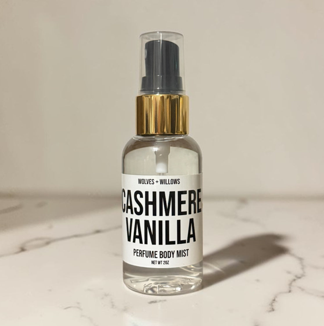 Perfume body mist bottle labeled 'Cashmere Vanilla' by Wolves & Willows on a marble surface.
