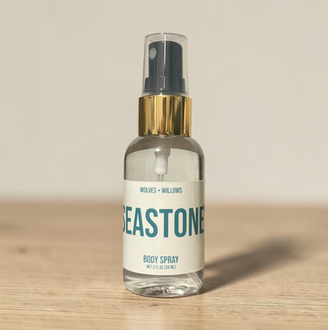 Body spray bottle labeled 'Beastone' by Wolves & Willows on a wooden surface with a beige background