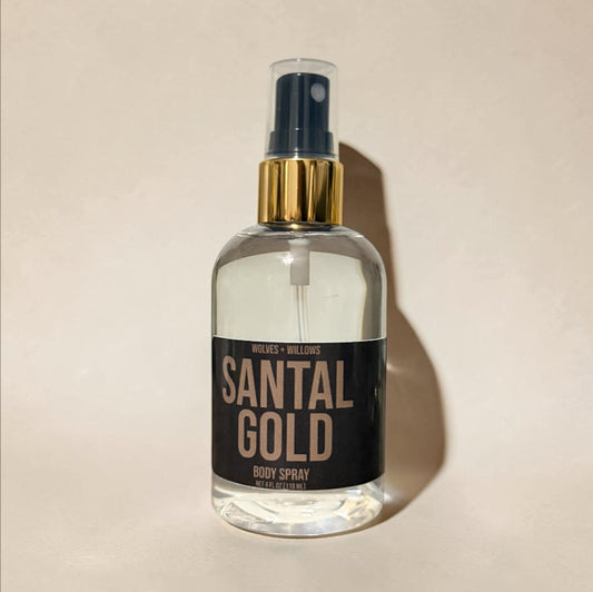 Clear spray bottle labeled 'Santal Gold' on a beige background