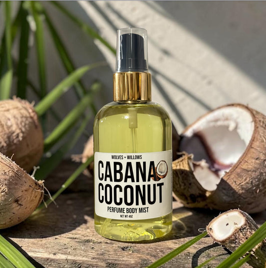 Bottle of 'Cabana Coconut' perfume body mist with coconuts on a wooden surface