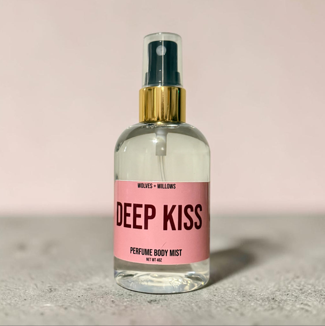 Perfume body mist bottle labeled 'Deep Kiss' by Wolves & Willows on a light background