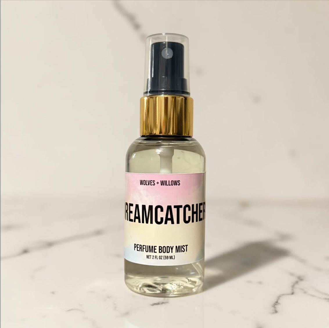 Perfume body mist bottle labeled 'Dreamcatcher' on a marble surface