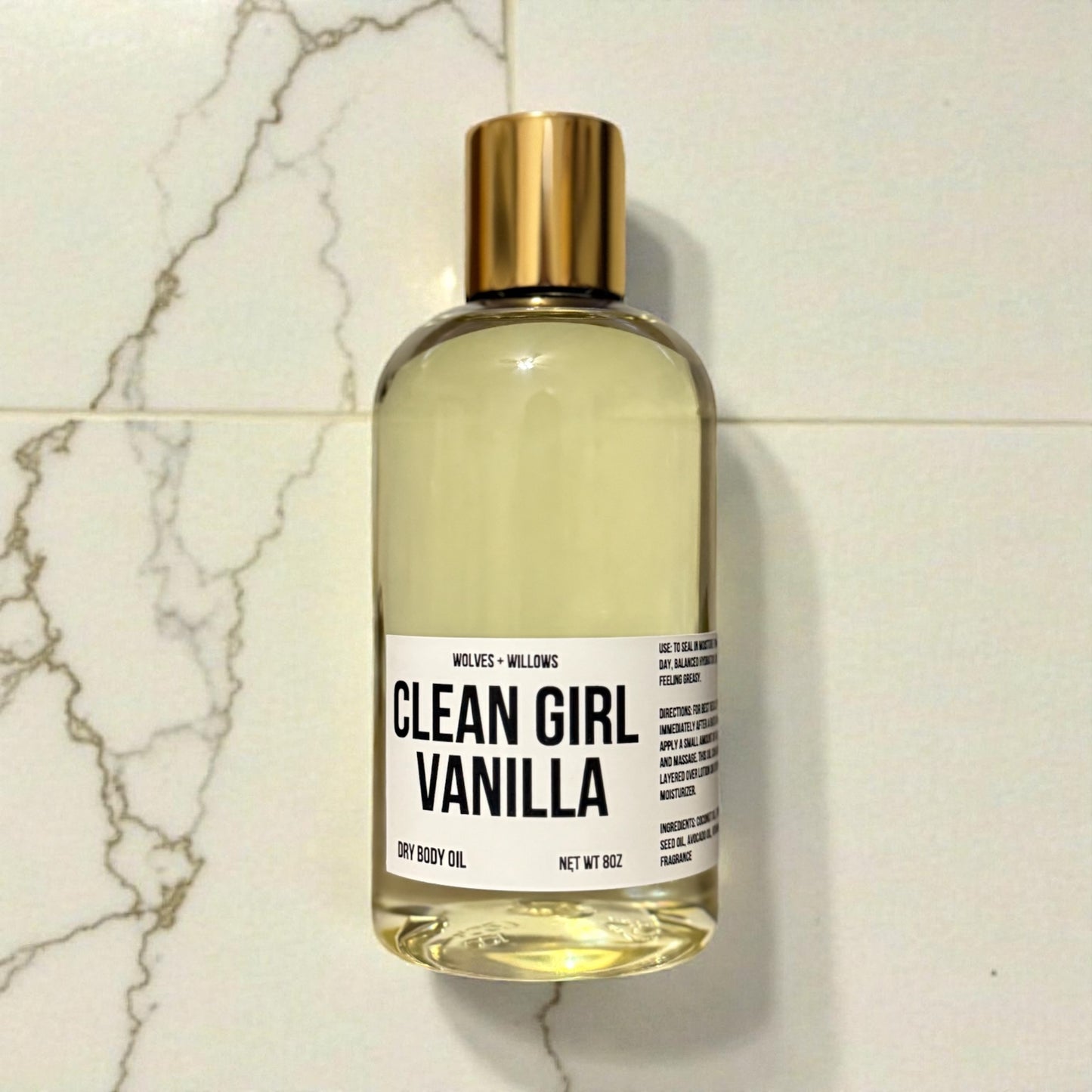 Bottle of 'Clean Girl Vanilla' dry body oil on a marble surface