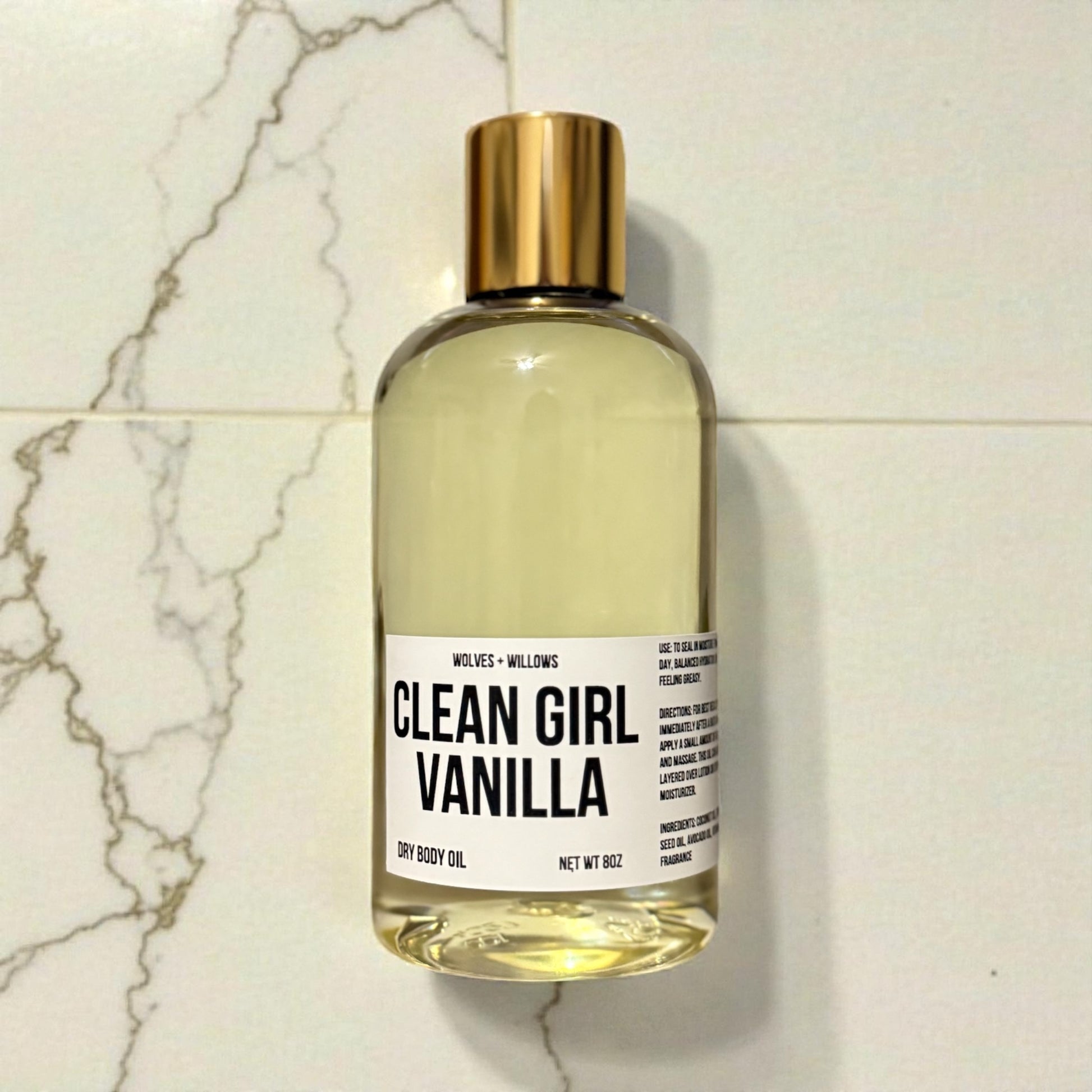 Bottle of 'Clean Girl Vanilla' dry body oil on a marble surface