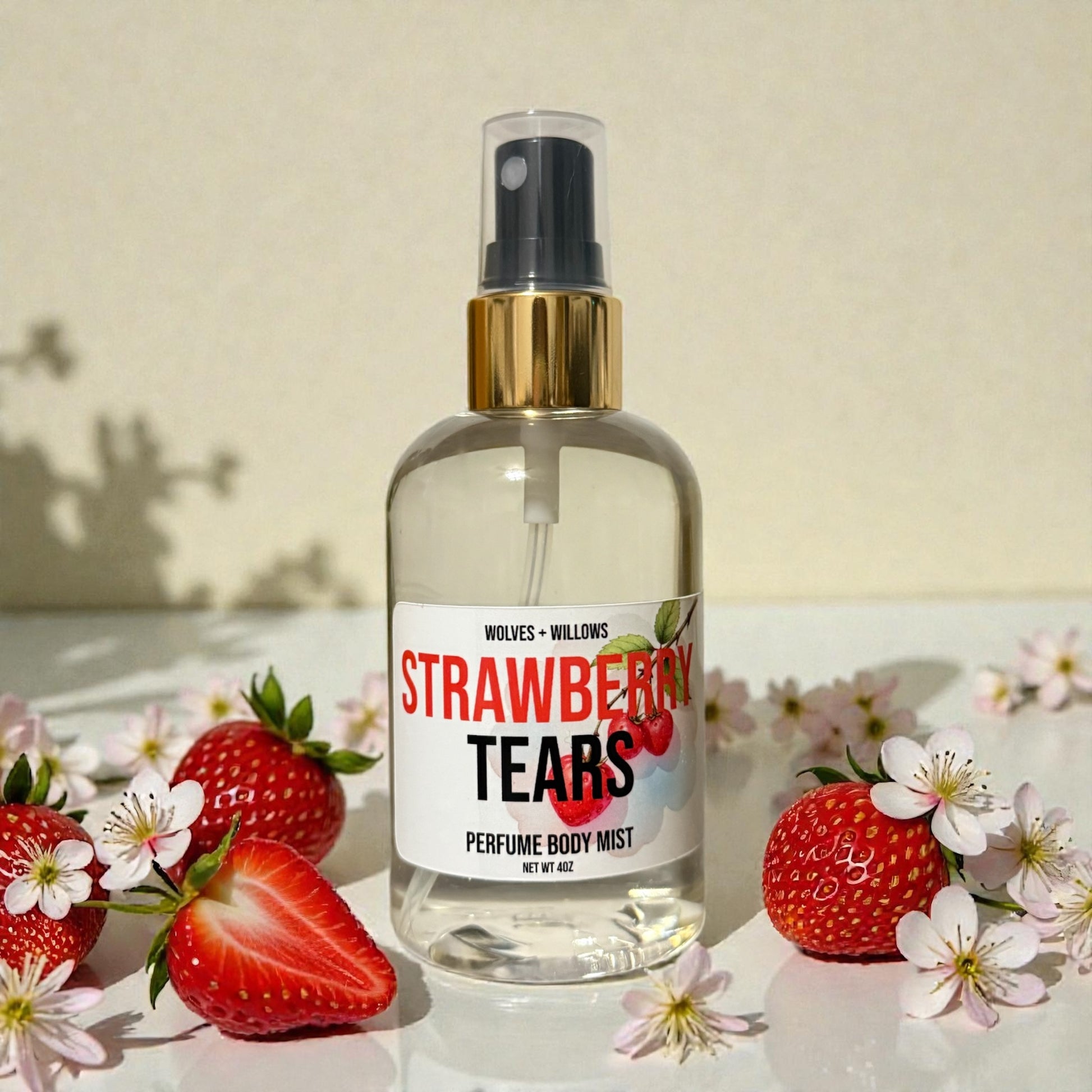 Perfume bottle labeled 'Strawberry Tears' surrounded by strawberries and flowers on a light background