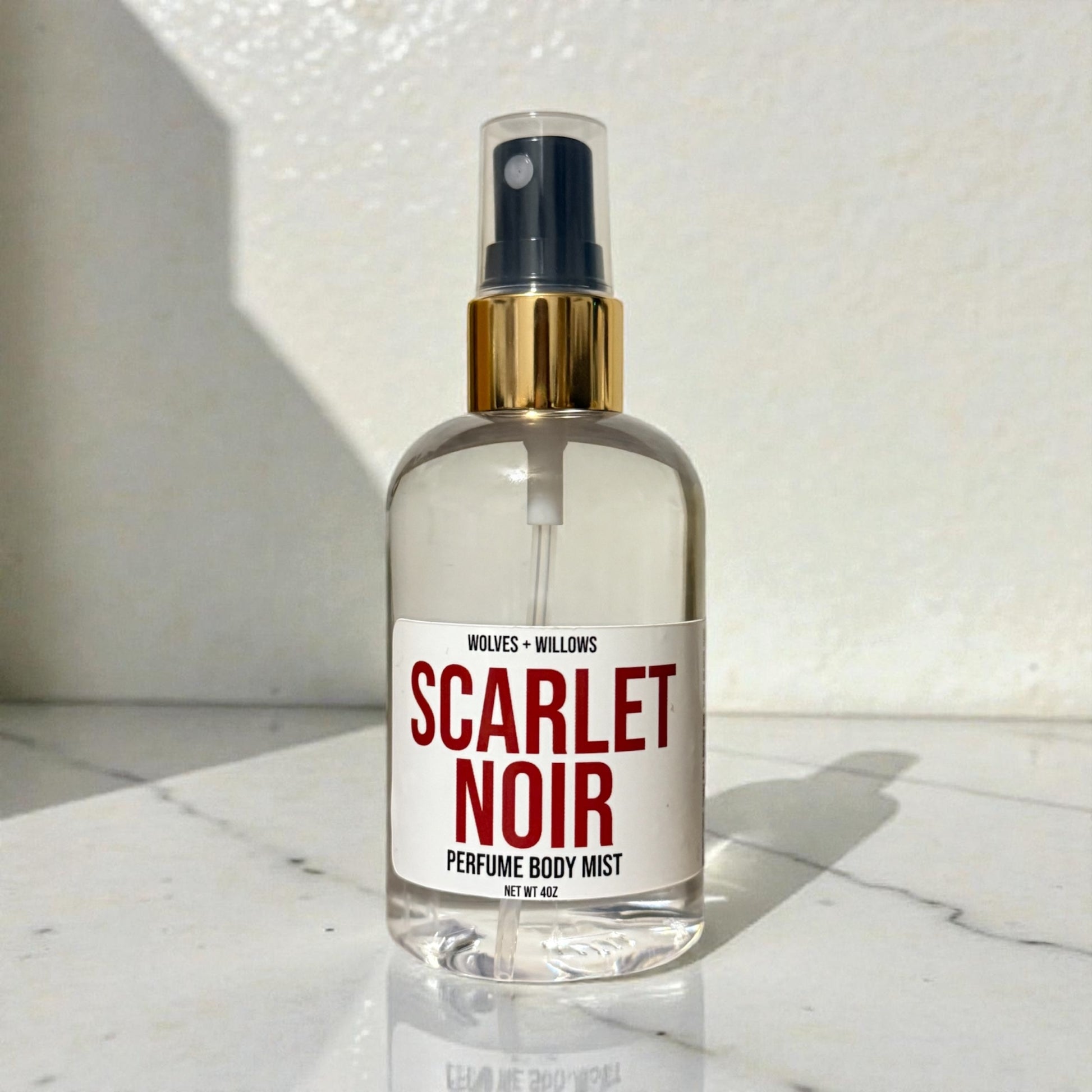 Scarlet Noir perfume body mist bottle on a marble surface
