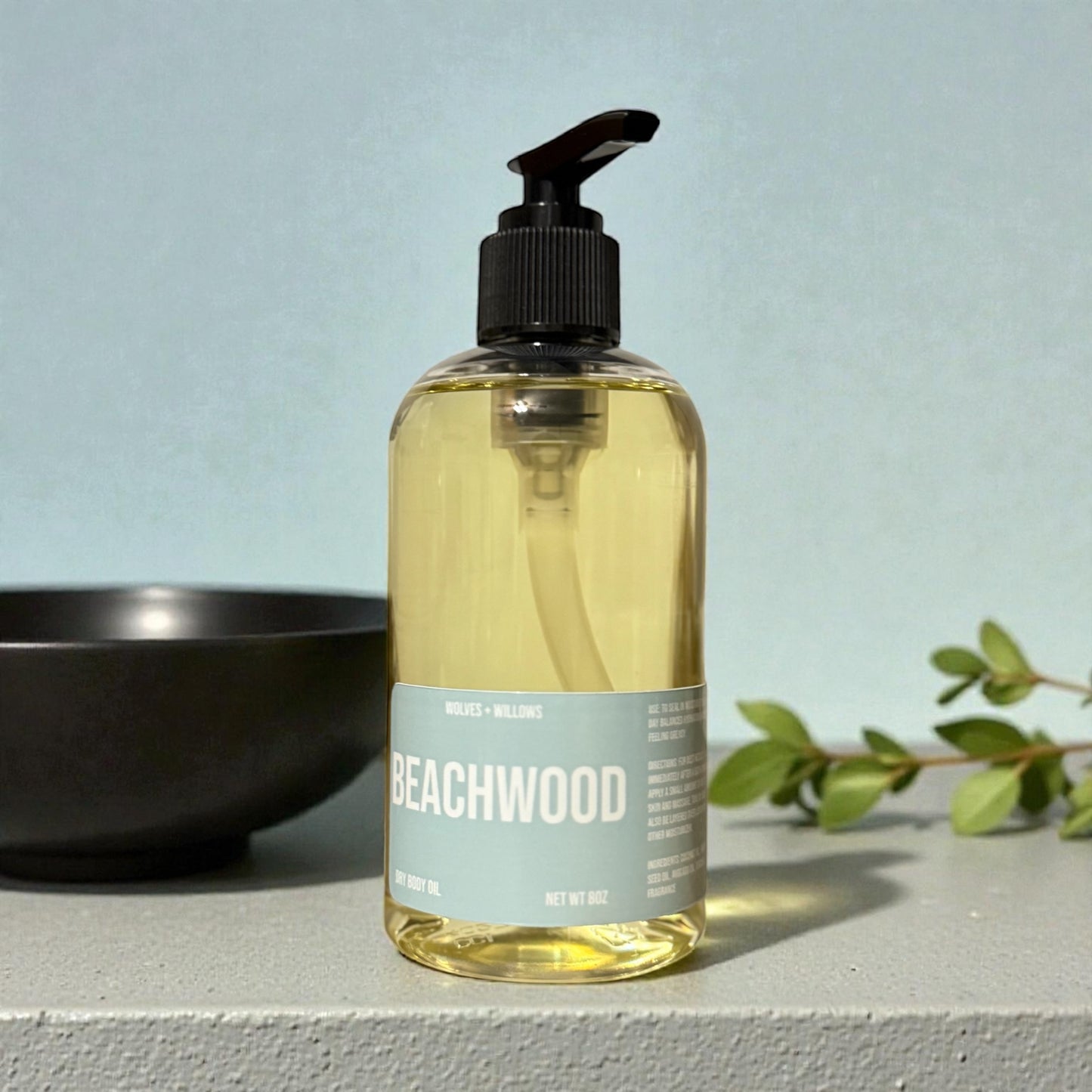 Bottle of Beachwood product with a pump dispenser on a light blue background