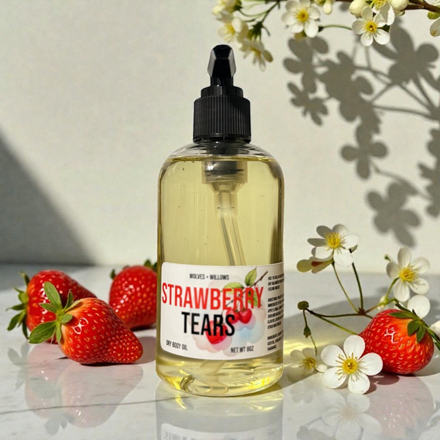 Bottle of 'Strawberry Tears' with black pump on a reflective surface