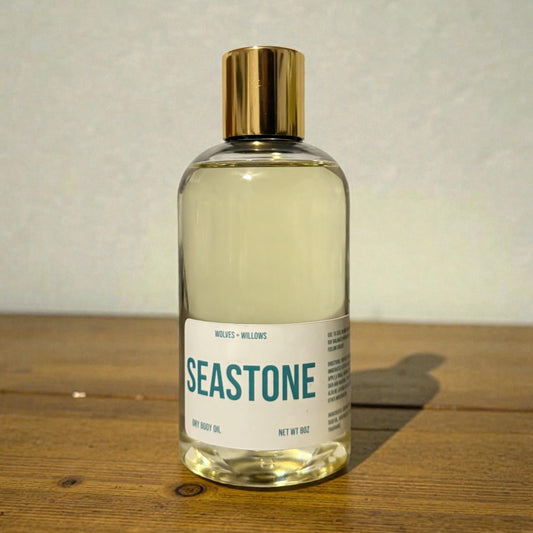 Bottle of 'Seastone' body oil on a wooden surface with a neutral background