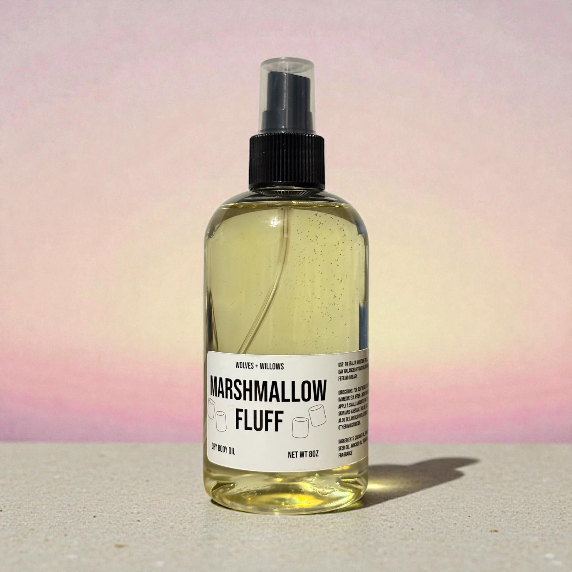 Bottle of 'Marshmallow Fluff' body oil with a label on a gradient background