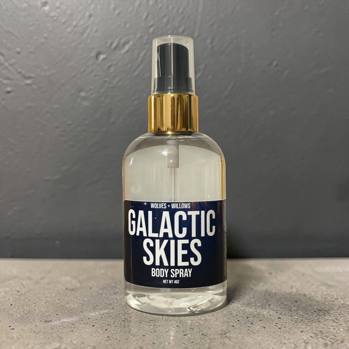 Body spray bottle labeled 'Galactic Skies' on a gray background