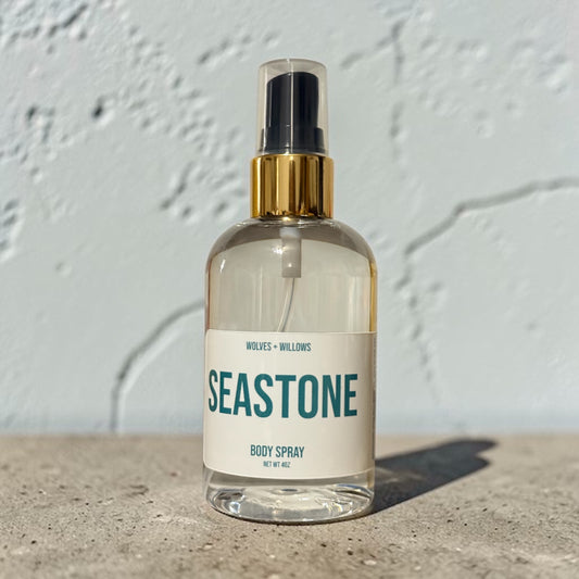 Body spray bottle labeled 'Seastone' on a textured surface with a light gray background