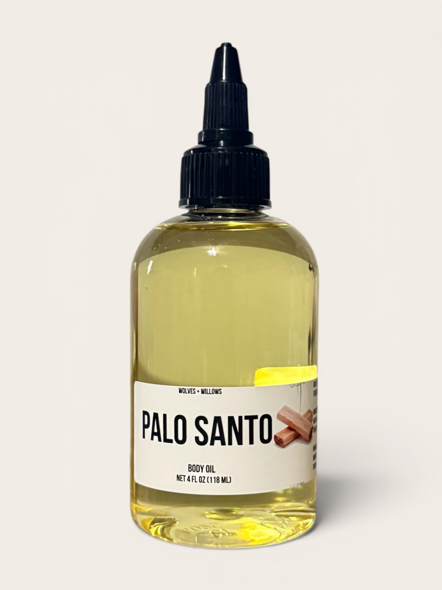 Bottle of Palo Santo body oil with a label on a white background