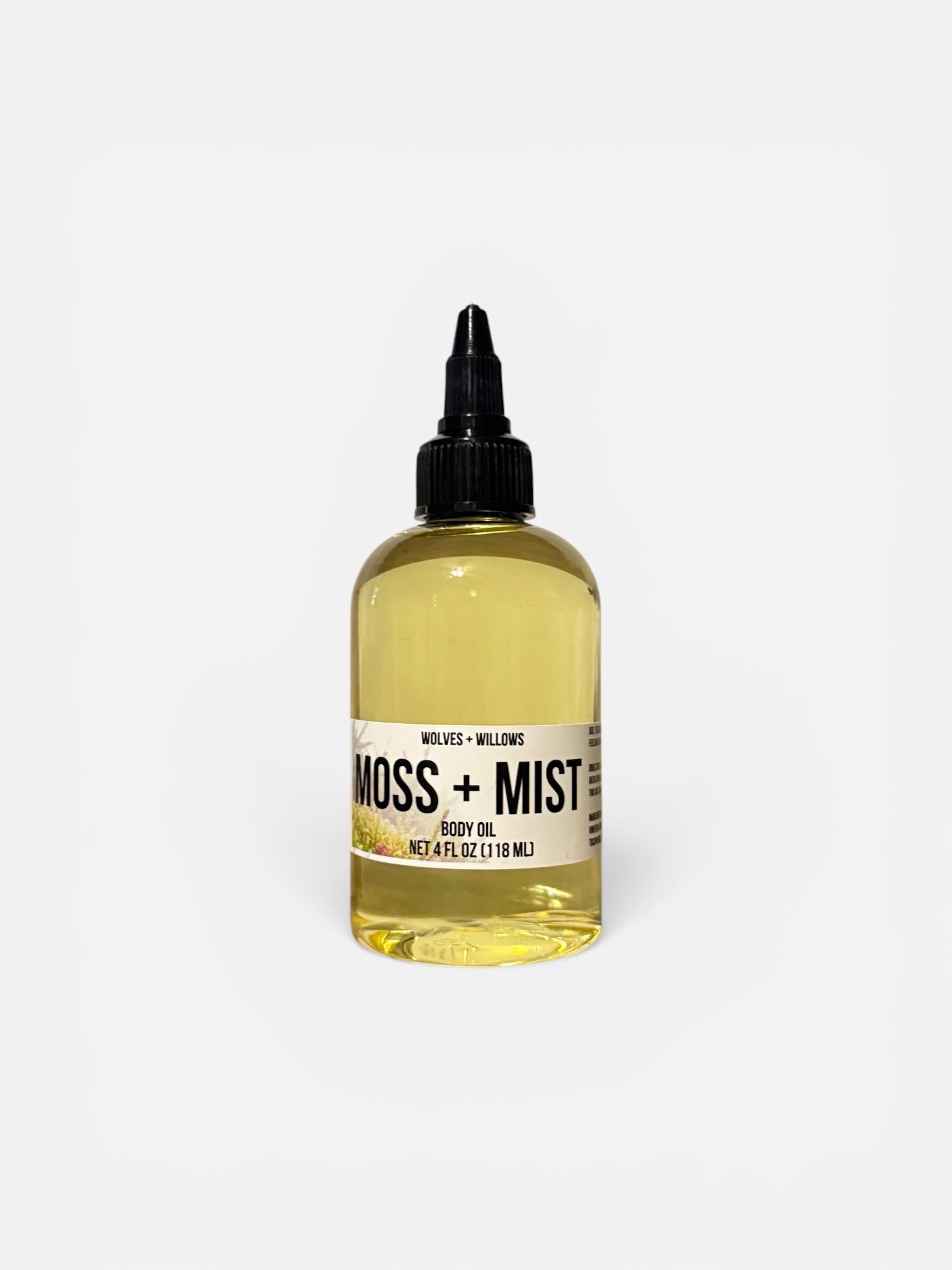 Bottle of Moss + Mist body oil on a white background