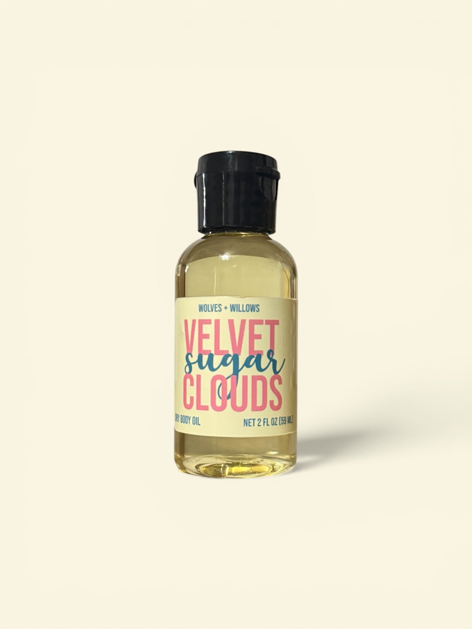 Bottle of 'Velvet Sugar Clouds' body oil with a yellow label on a white background