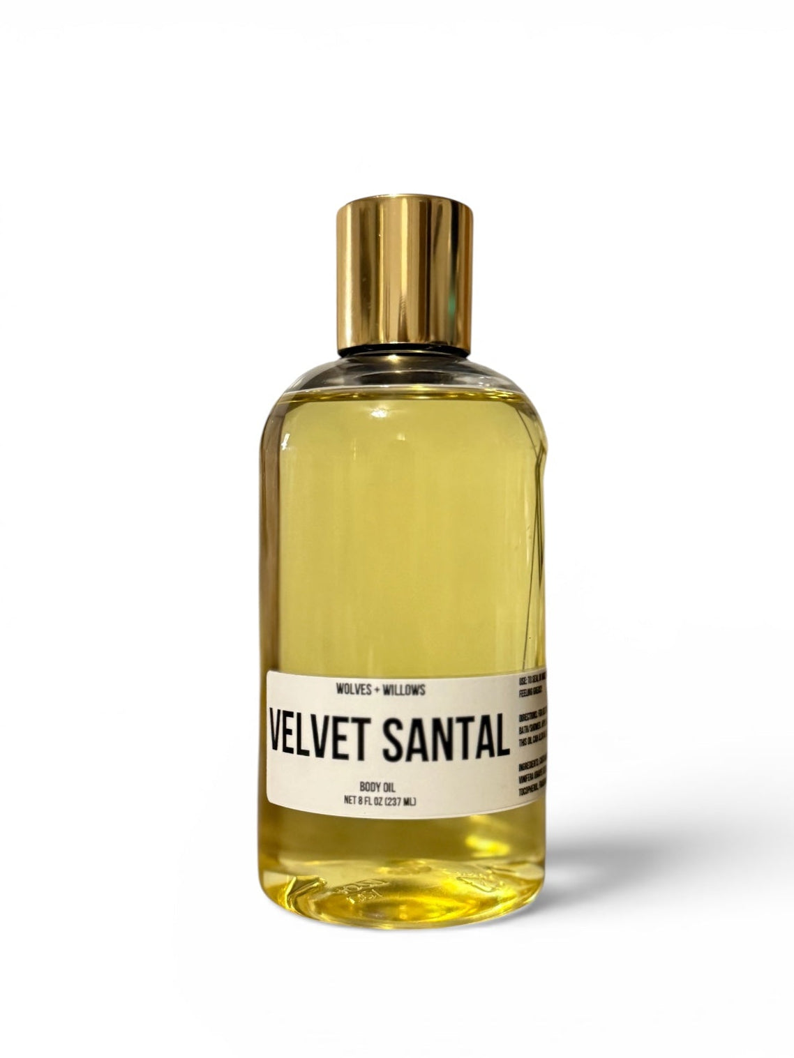 Bottle of 'Velvet Santal' body oil with a gold cap on a white background