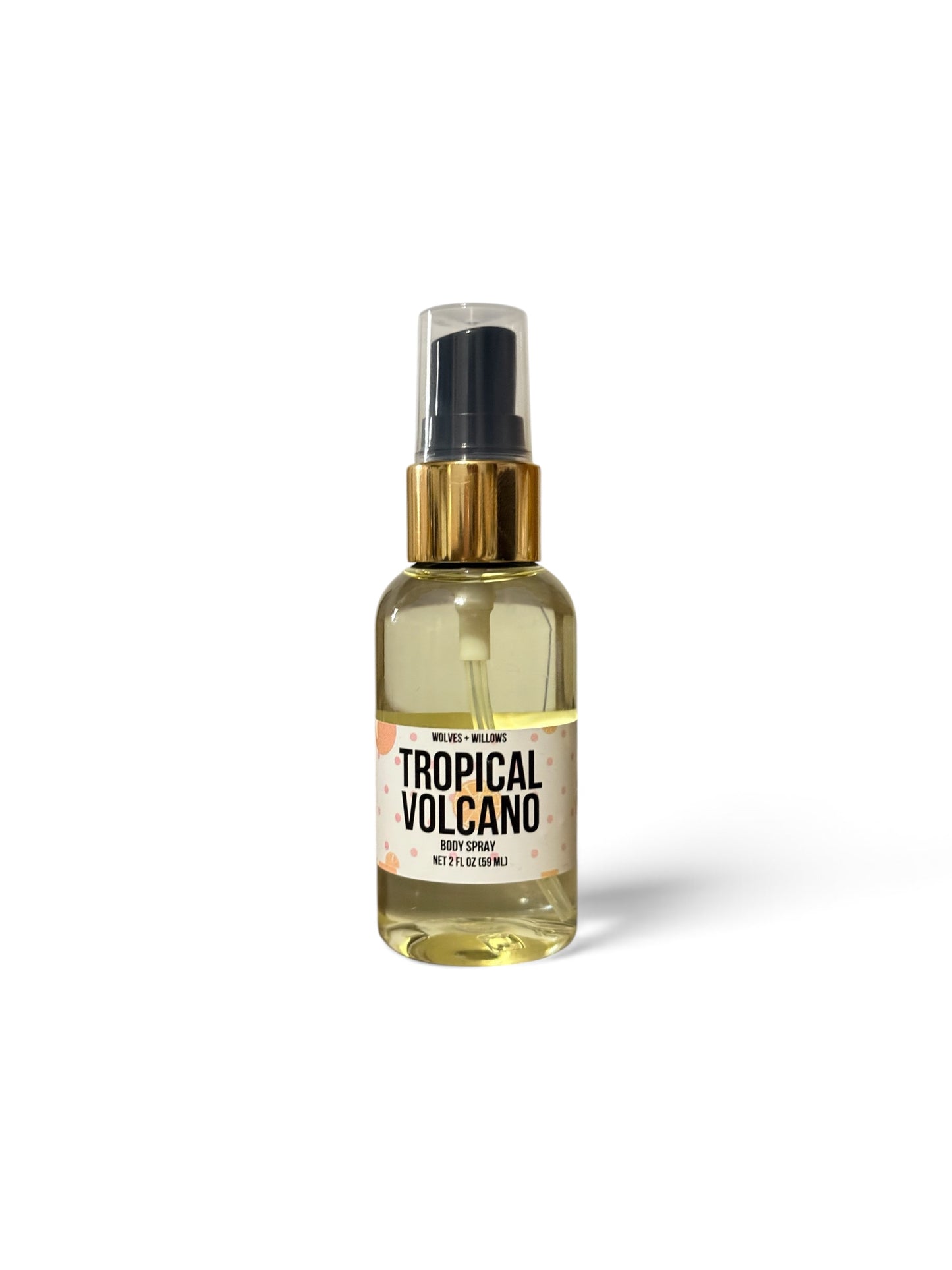 A clear spray bottle filled with pale yellow liquid, featuring a black spray top, a metallic gold collar, and a white label that reads 'TROPICAL VOLCANO'.