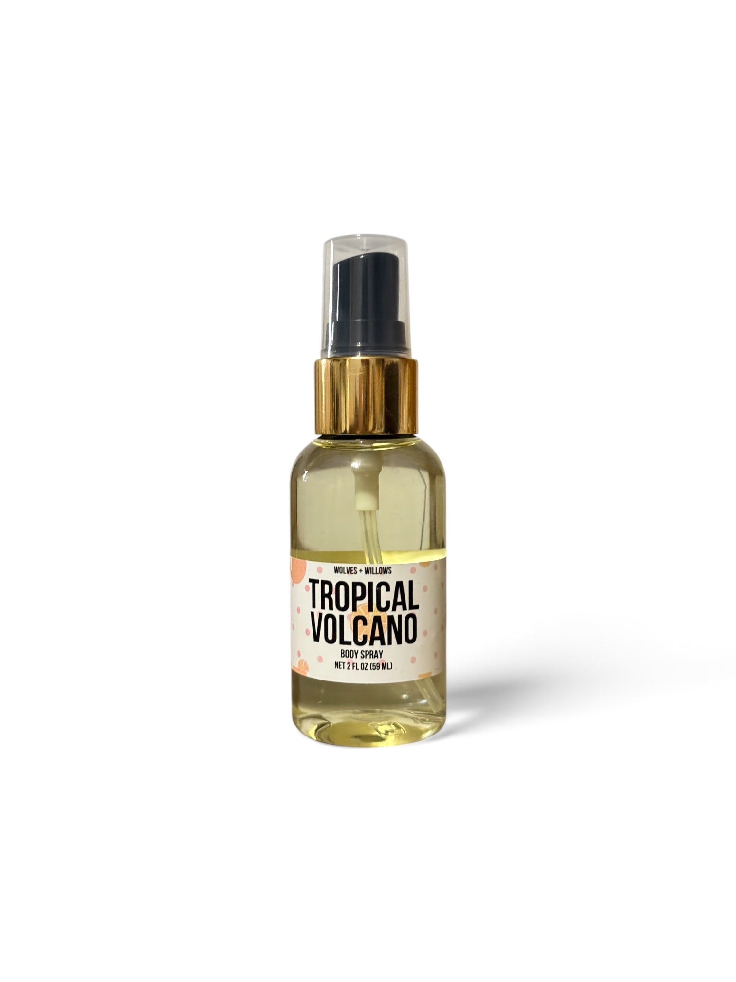 A clear spray bottle filled with pale yellow liquid, featuring a black spray top, a metallic gold collar, and a white label that reads 'TROPICAL VOLCANO'.