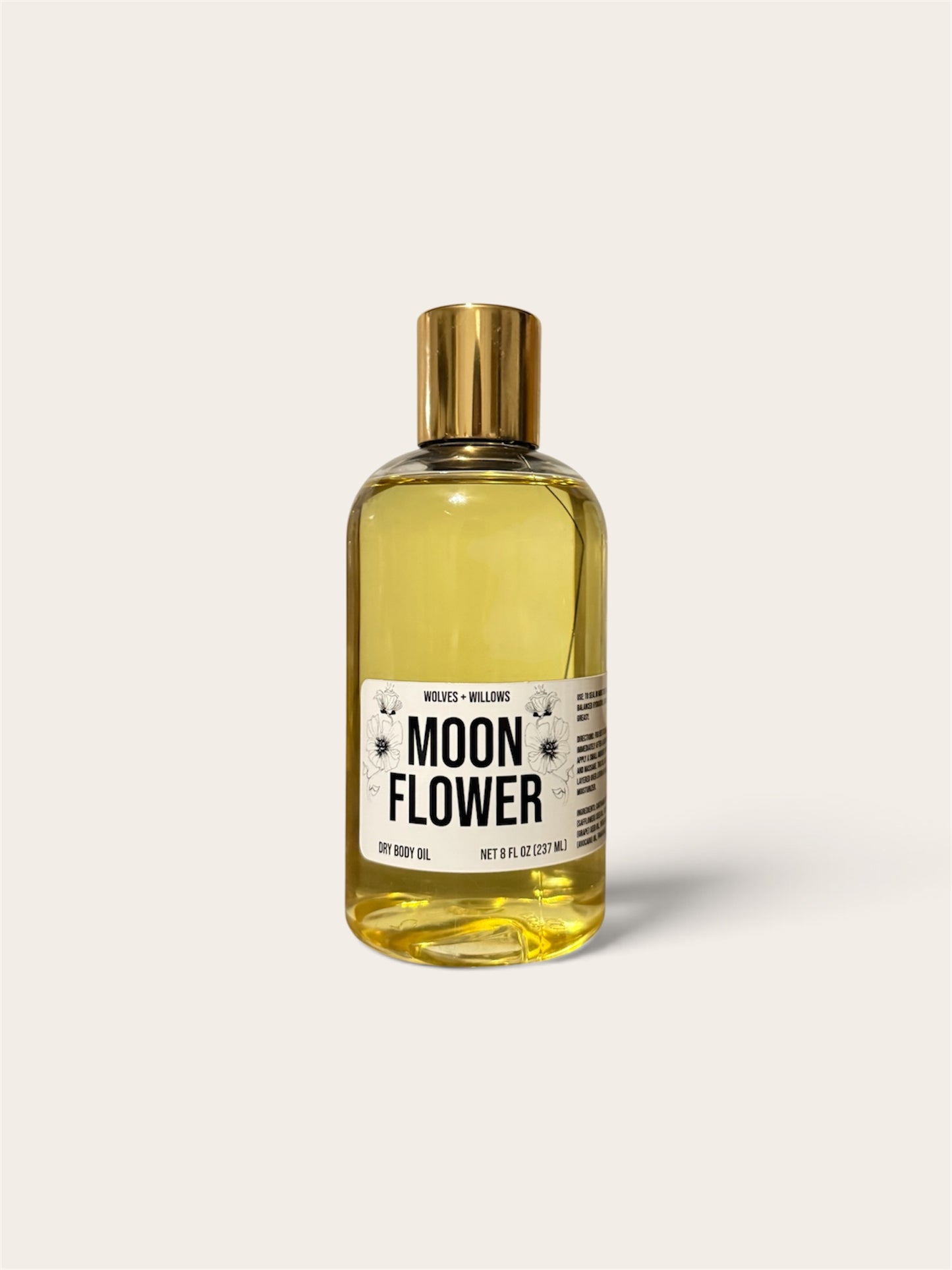 A bottle of Moon Flower body oil by Melt Cosmetics, filled with a golden-yellow liquid and topped with a metallic gold cap, set against a solid off-white background.