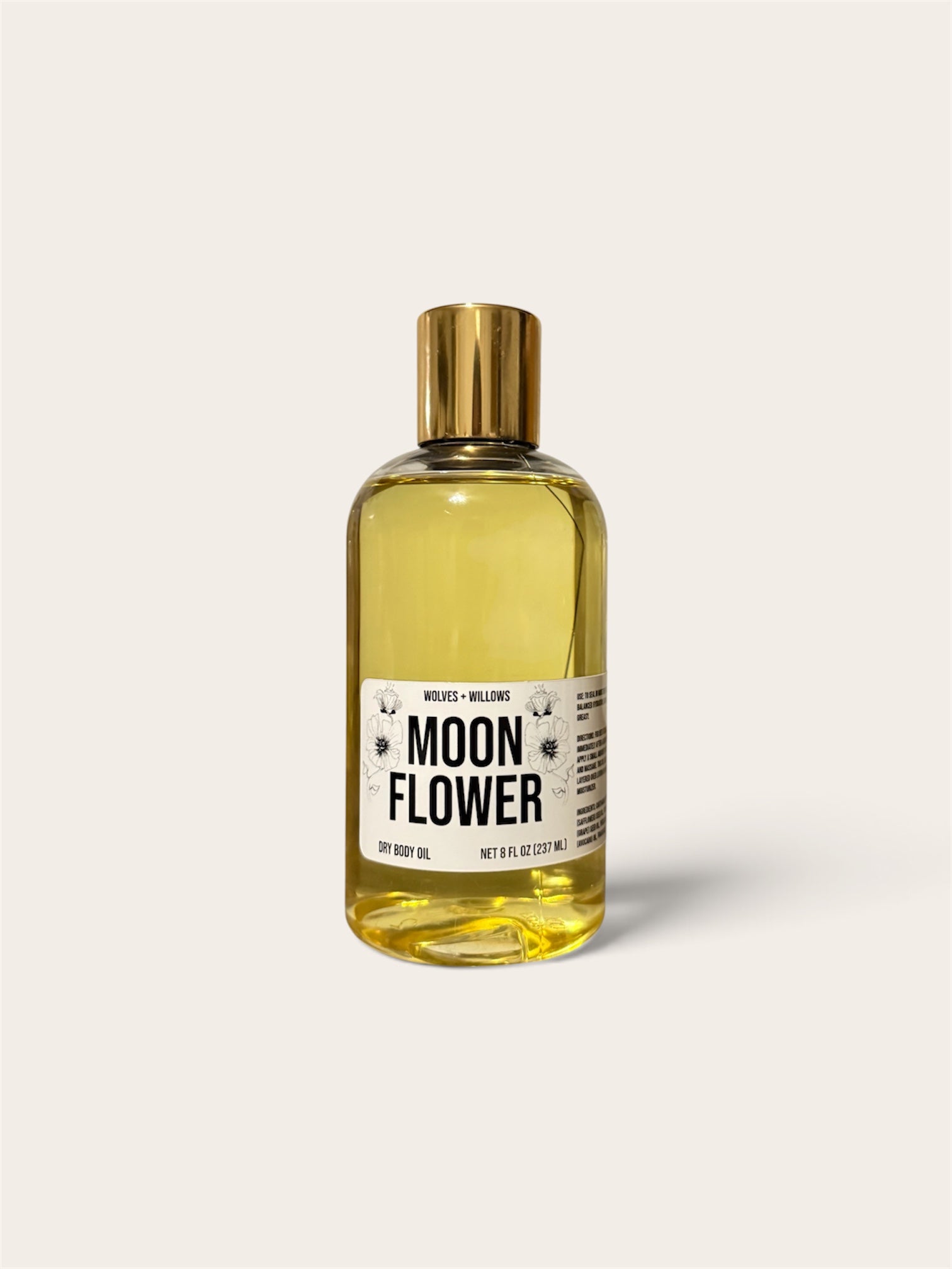 A bottle of Moon Flower body oil by Melt Cosmetics, filled with a golden-yellow liquid and topped with a metallic gold cap, set against a solid off-white background.