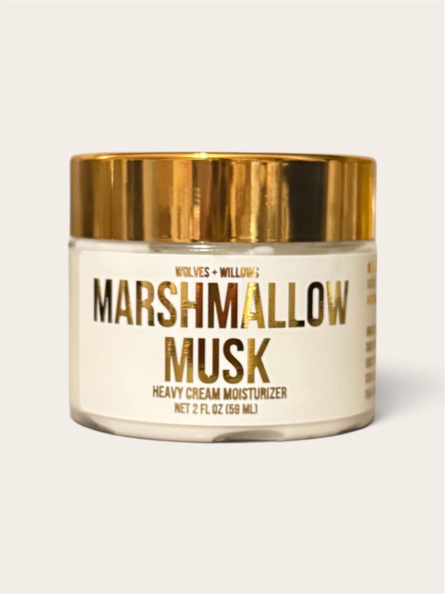 Wolves & Willow's Marshmallow Musk Heavy Cream Moisturizer in a clear glass jar with a shiny gold lid and a cream-colored label.