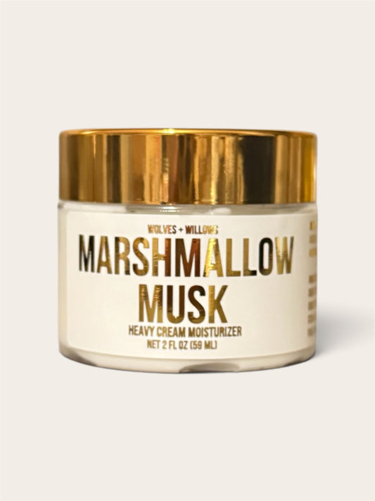 Wolves & Willow's Marshmallow Musk Heavy Cream Moisturizer in a clear glass jar with a shiny gold lid and a cream-colored label.