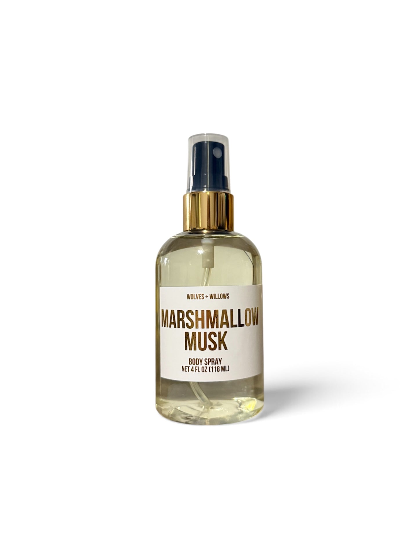A clear glass body spray bottle filled with pale yellow liquid, featuring a cream label with brown text that reads 'MARSHMALLOW MUSK' and 'VELVET + WELLING'. The bottle has a gold-tone spray collar and a dark spray top, set against a clean white background with a soft shadow.