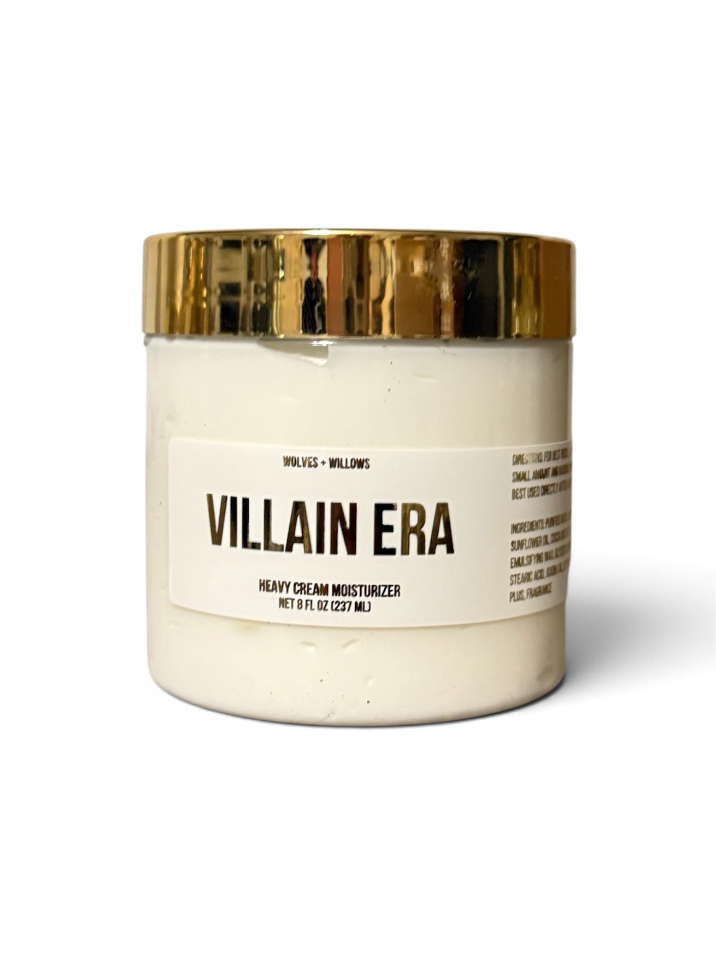 A jar of Villain Era Heavy Cream Moisturizer with an off-white cream product and a shiny gold metallic lid, set against a plain white background.