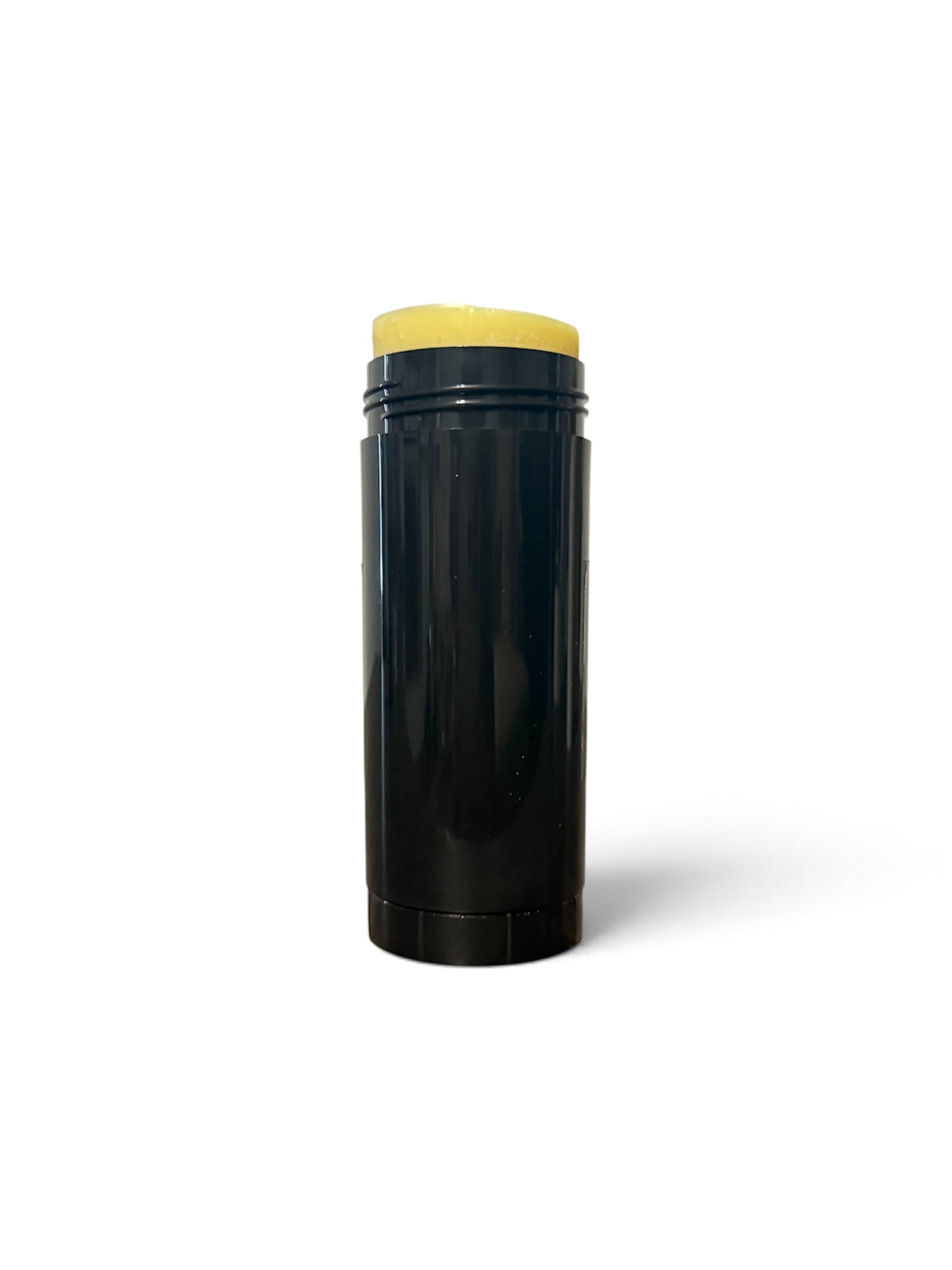 A black cylindrical stick container with a yellow cream or balm product visible at the top, photographed on a clean white background.