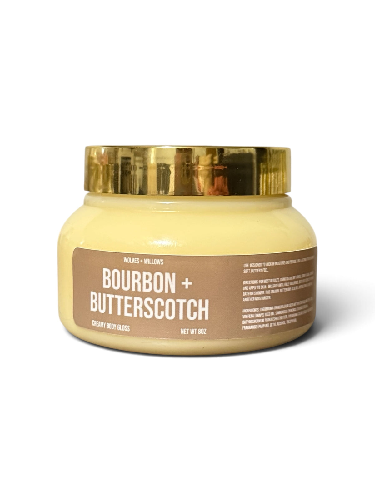 bourbon and butterscotch scented body butter in clear jar, with brown label, and gold lid.