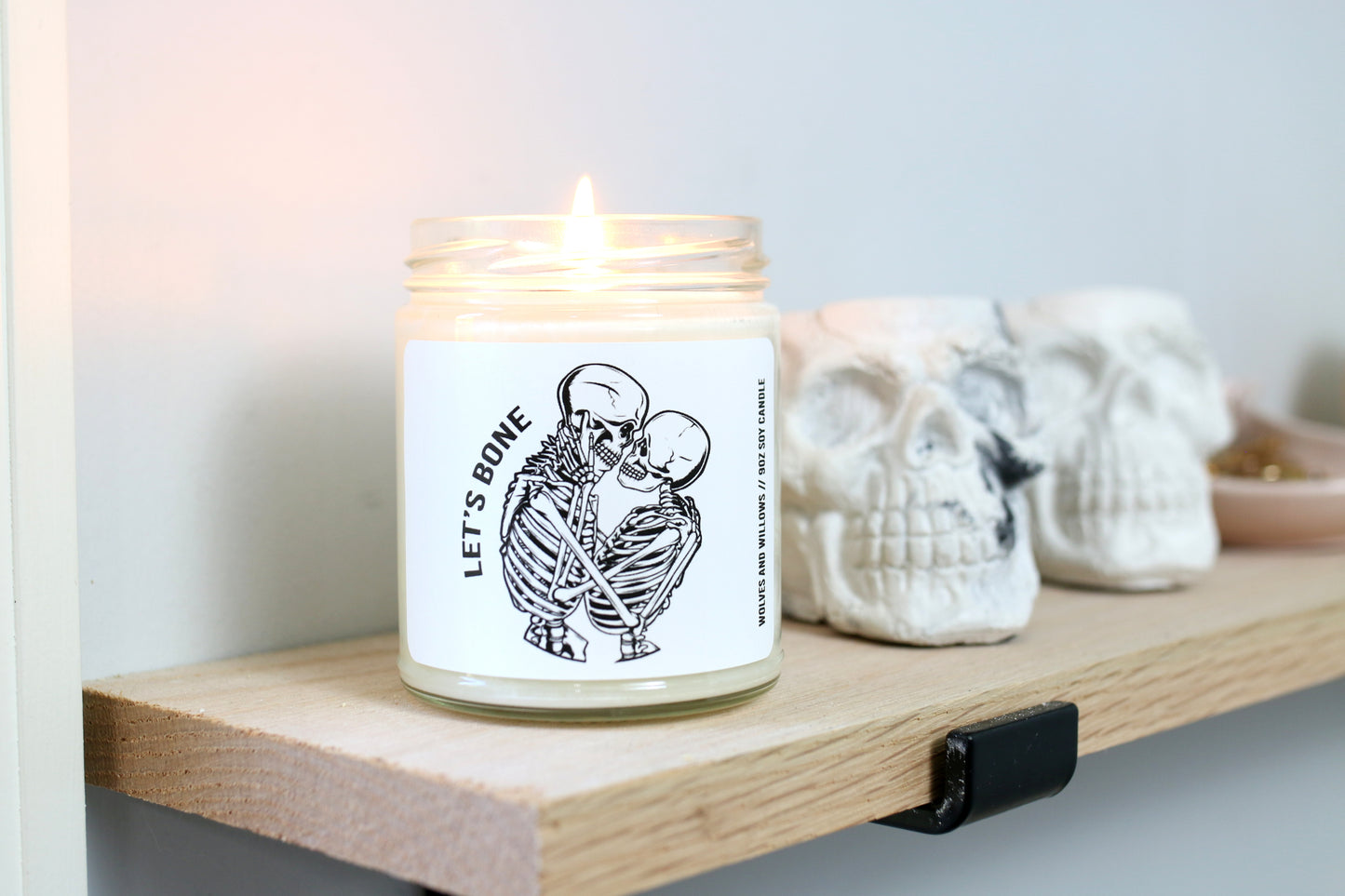 9oz soy candle that reads "let's bone" with two skeletons kissing.